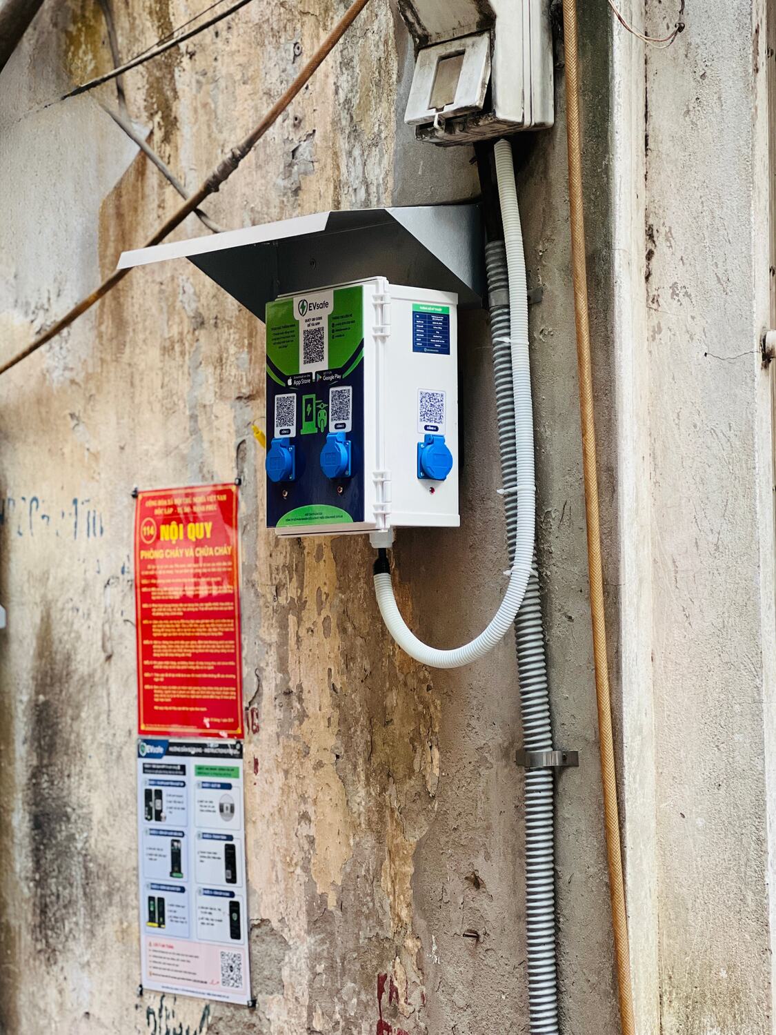 Hộp sạc xe máy điện EVsafe gắn tường kèm nội quy phòng cháy chữa cháy trong ngõ khu tập thể Nguyên Hồng, Hà Nội
