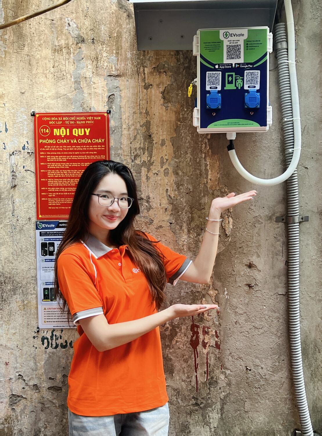 Nhân viên EVsafe giới thiệu hộp sạc xe máy điện lắp tại tạp hóa khu tập thể Nguyên Hồng, Hà Nội