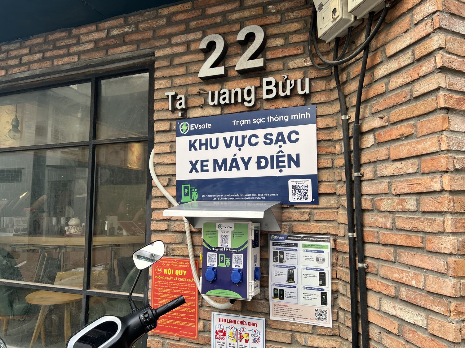 Hộp sạc xe máy điện EVsafe và bảng hướng dẫn tại quán cà phê 22 Tạ Quang Bửu, Hà Nội